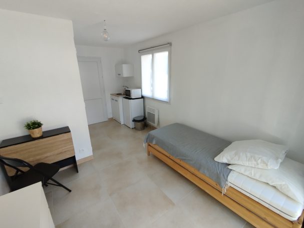 Provence Verte: suite lit double à la campagne, jardin Chambre simple avec un lit, bureau, et kitchenette, murs blancs et sol clair.