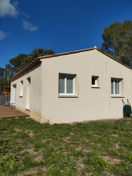 Provence Verte : 3 chambres, jardin, piscine Maison de plain-pied avec murs blancs et fenêtres sur un terrain verdoyant.