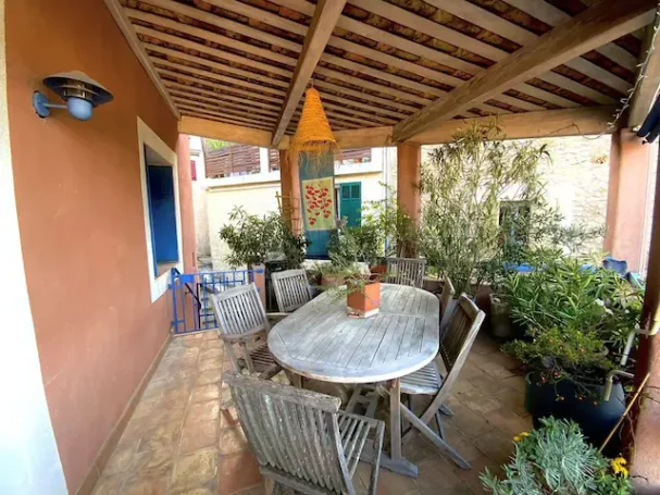 Provence Verte: maison de village, 4 chambres, 2 terrasses Terrasse accueillante avec une table en bois et des chaises entourées de plantes vertes.